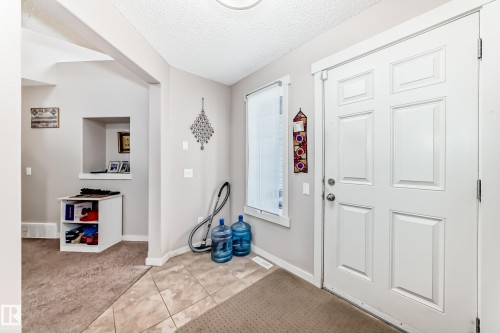 Entryway featuring a paneled door, tile flooring, and a large side window - 2808 36 Avenue, Edmonton, AB 
