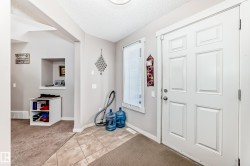 Entryway featuring a paneled door, tile flooring, and a large side window - 