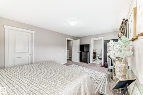 Spacious bedroom featuring light neutral wall tones, textured carpeting, and a built-in overhead light fixture - 2808 36 Avenue, Edmonton, AB 