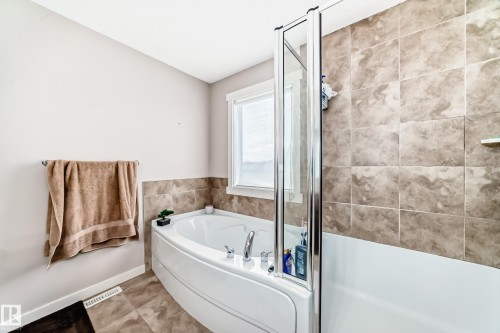 Corner soaking tub with polished chrome fixtures and a glass shower partition - 2808 36 Avenue, Edmonton, AB 