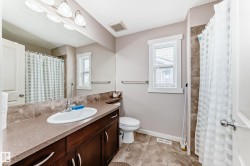 Bathroom featuring a large vanity with a single basin sink, extensive countertop space, and dark wood cabinetry - 
