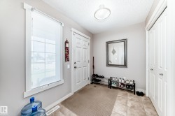 Entryway featuring neutral wall colors, a white paneled door, and a white framed window with a roller shade - 