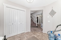Tile flooring, white bi-fold closet doors, and light-toned wall paint define this entry area - 