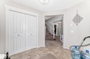 Tile flooring, white bi-fold closet doors, and light-toned wall paint define this entry area - 2808 36 Avenue, Edmonton, AB 