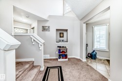 Split-level entry with carpeted stairs and white painted railings - 