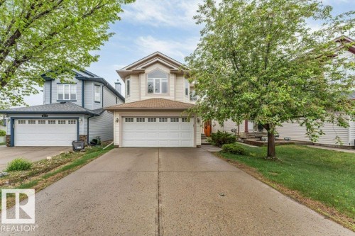 Two-story property featuring a front-facing attached double garage and a multi-pane bay window - 16315 55 Street, Edmonton, AB 