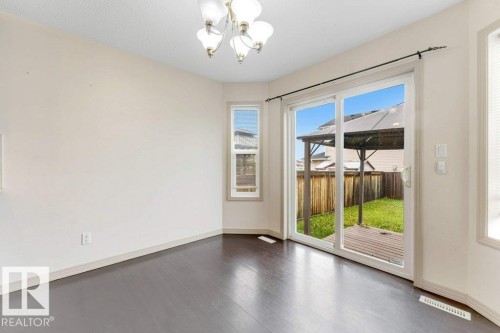 Dining area with dark wood-finish flooring and a multi-light ceiling fixture - 16315 55 Street, Edmonton, AB 
