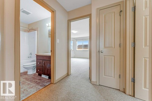 Corridor featuring light beige carpeting and trim - 16315 55 Street, Edmonton, AB 