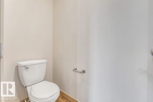 White two-piece toilet with a chrome flush lever - 16315 55 Street, Edmonton, AB 