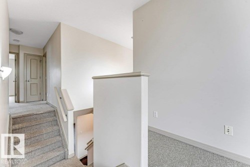 Carpeted staircase with light beige walls and white trim - 16315 55 Street, Edmonton, AB 