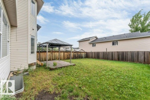 Expansive backyard featuring a gazebo-covered wooden deck, a fully fenced perimeter, and a window well - 16315 55 Street, Edmonton, AB 