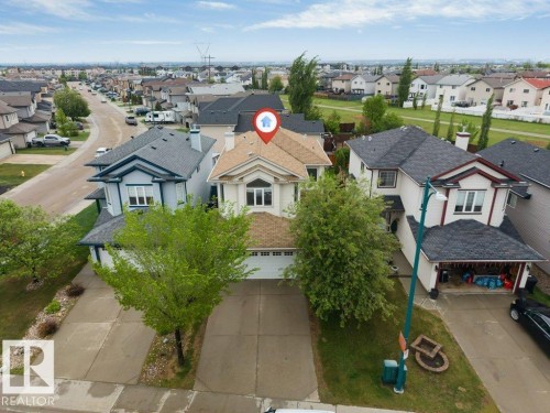 Two-story residence with an attached garage, light-colored siding, and a gabled roofline - 16315 55 Street, Edmonton, AB 