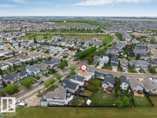 Residential property featuring a pitched roof and a rear yard with a fire pit - 16315 55 Street, Edmonton, AB 