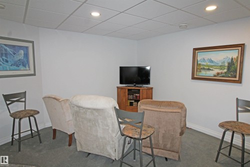 Recessed lighting illuminates this carpeted room featuring a drop ceiling and white baseboards - 334 7001 Northview Drive, Wetaskiwin, AB - Indoor