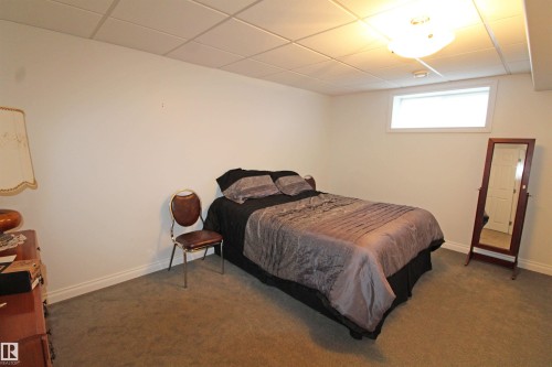 Carpeted room featuring a drop ceiling with recessed lighting and a single horizontal window - 334 7001 Northview Drive, Wetaskiwin, AB - Indoor Photo Showing Bedroom