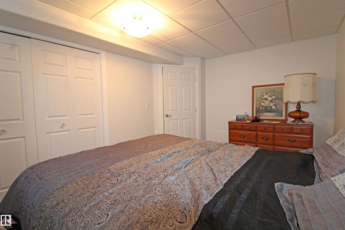 Interior room featuring white walls, a grid-patterned ceiling, and a flush-mount ceiling light fixture - 334 7001 Northview Drive, Wetaskiwin, AB - Indoor Photo Showing Bedroom