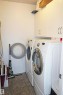 Dedicated laundry area featuring tile flooring and built-in white cabinetry - 334 7001 Northview Drive, Wetaskiwin, AB  - Indoor Photo Showing Laundry Room 