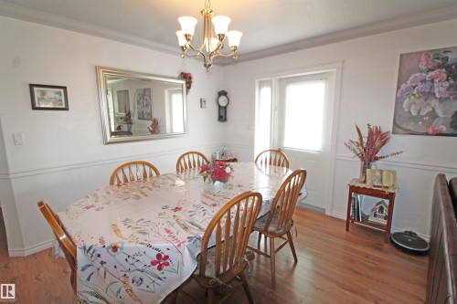 Bright room featuring wood-finish flooring, white wainscoting, and crown molding - 334 7001 Northview Drive, Wetaskiwin, AB - Indoor Photo Showing Dining Room