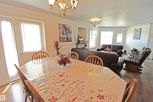 Open-concept living area featuring crown molding and wood-finish flooring - 334 7001 Northview Drive, Wetaskiwin, AB - Indoor Photo Showing Dining Room