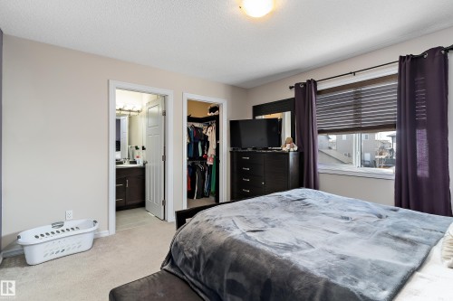 Carpeted bedroom featuring neutral wall tones, a built-in closet with shelving, and a window with blinds - 6822 Cardinal Link, Edmonton, AB 