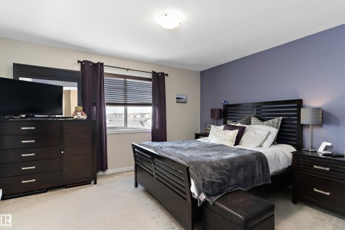 Carpeted bedroom with a window featuring horizontal blinds and dark curtains - 6822 Cardinal Link, Edmonton, AB 
