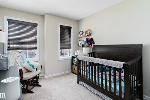 Bright room featuring two windows with dark wood-finish blinds, light neutral wall paint, and soft carpet flooring - 6822 Cardinal Link, Edmonton, AB 