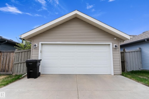 Single-car garage with beige horizontal siding and a white panel garage door - 6822 Cardinal Link, Edmonton, AB 