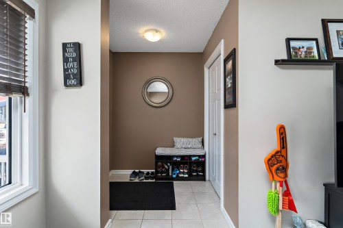 Entryway featuring light-toned wall paint, ceramic tile flooring, and a window with horizontal blinds - 6822 Cardinal Link, Edmonton, AB 