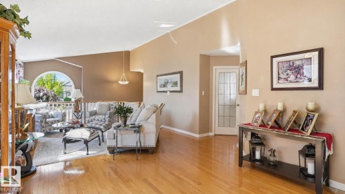 Hardwood flooring throughout the main level featuring a curved arch window with white railings - 856 Graham Wynd, Edmonton, AB 