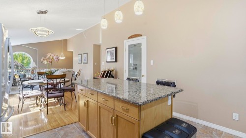 Kitchen island with light wood cabinetry and a speckled stone countertop - 856 Graham Wynd, Edmonton, AB 