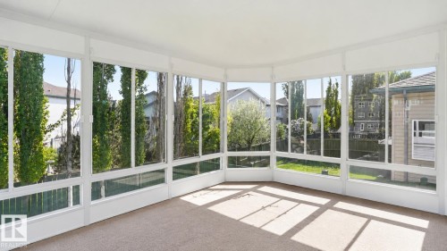 Sunroom featuring floor-to-ceiling windows, white window frames, and light-colored carpet - 856 Graham Wynd, Edmonton, AB 