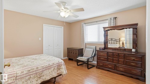 Room featuring wood-finish flooring, a double-panel closet with louvered doors, and neutral wall tones - 856 Graham Wynd, Edmonton, AB 