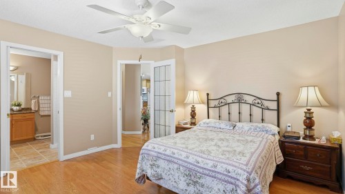 Bedroom featuring wood-finish flooring, a ceiling fan with integrated lighting, and neutral wall tones - 856 Graham Wynd, Edmonton, AB 