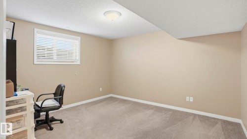 Neutral-toned room featuring a single window with horizontal blinds, light beige walls, and light gray carpeting - 856 Graham Wynd, Edmonton, AB 