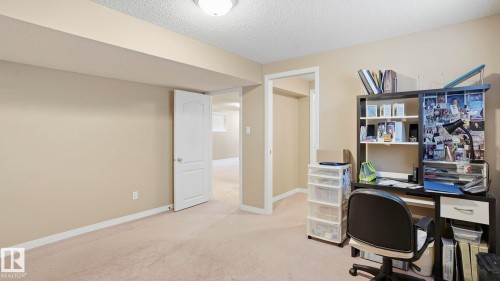 Carpeted room featuring neutral-toned walls, white baseboards, and a semi-flush mount ceiling light fixture - 856 Graham Wynd, Edmonton, AB 