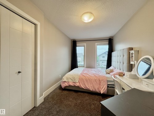 Room featuring neutral wall tones, textured carpet flooring, and a flush-mount ceiling light - 3254 Allan Way, Edmonton, AB 