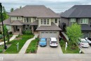 Contemporary residence with a multi-gabled roofline, stone and siding exterior, two-car garage, and manicured front landscaping - 3254 Allan Way, Edmonton, AB 
