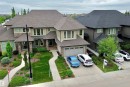 Multi-level residence featuring a prominent gabled roofline, stone and siding facade, and multiple large windows - 3254 Allan Way, Edmonton, AB 