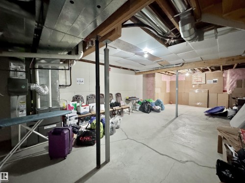 Unfinished basement featuring exposed joists and structural beams, concrete flooring, and visible utility systems - 3254 Allan Way, Edmonton, AB 