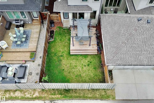 Expansive backyard featuring a green lawn, wood deck, and a privacy fence - 3254 Allan Way, Edmonton, AB 