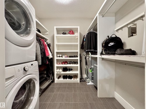 Laundry and storage area with stacked washer and dryer - 3254 Allan Way, Edmonton, AB 