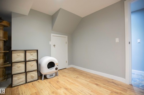 Recessed wall with light gray paint, wood-finish flooring, and white baseboards - 52 Mohawk Crescent, Leduc, AB 