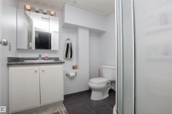 Bathroom featuring a white vanity with a gray countertop, an integrated sink, and a mirrored medicine cabinet - 
