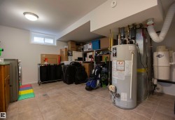 Utility room featuring ceramic tile flooring, a built-in water heater, and a central vacuum system - 