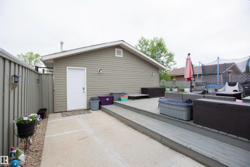 Detached accessory building with gray horizontal siding and white trim - 52 Mohawk Crescent, Leduc, AB 