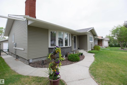 Ranch-style residence featuring horizontal siding and a red brick chimney - 52 Mohawk Crescent, Leduc, AB 