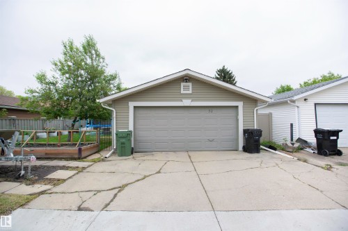 Detached garage with horizontal siding, a gable roof, and a single garage door - 52 Mohawk Crescent, Leduc, AB 