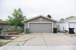 Detached garage with horizontal siding, a gable roof, and a single garage door - 