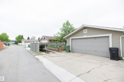 Detached garage with horizontal siding and a panel-style garage door - 