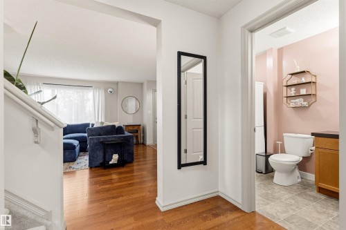 Hardwood-finish flooring extending from the entryway into a bright living area - 14807 141 Street, Edmonton, AB 